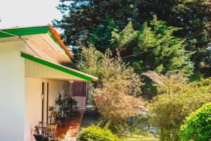 uma casa com um telhado verde e algumas árvores em Pousada São Chico Eco Village em São Francisco de Paula