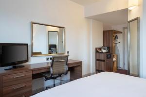 a hotel room with a bed and a desk with a television at Leonardo Hotel Leeds in Leeds +26 photos
