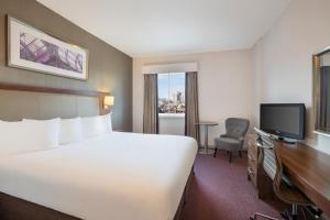 a hotel room with a large bed and a tv at Leonardo Hotel Leeds in Leeds