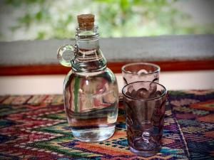 a bottle and a glass cup on a table at Δ CaSa ArkAanA Δ NatUrE LoVeRs' WeLLNesS SaNcTuaRy in Tulum