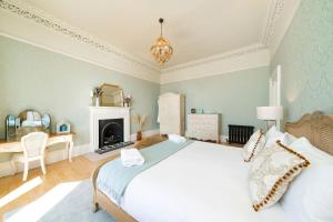 a bedroom with a large bed and a fireplace at Villa by the Sea in Broughty Ferry