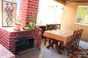 a room with a brick fireplace and a table and chairs at Ramneek Homestay in Joshīmath