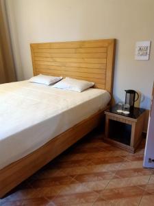 sypialnia z łóżkiem z drewnianym zagłówkiem i stołem w obiekcie Kasauli Inn w mieście Kasauli