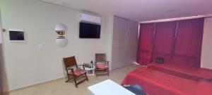 a bedroom with a red bed and a table and chairs at Fenix 4 in Formosa