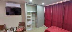 1 dormitorio con cortina roja y TV en Fenix 4 en Formosa