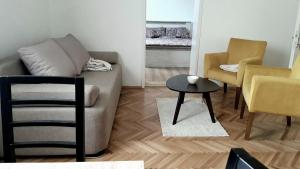 a living room with a couch and a table and chairs at Apartman river side in Soko Banja