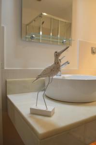 a statue of a bird standing on top of a sink at ғᴜɴᴄʜᴀʟ ᴄᴇɴᴛᴇʀ- ᴅᴏᴡɴᴛᴏᴡɴ in Funchal