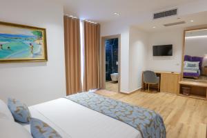 a hotel room with a bed and a television at Bora Bora Hotel Ksamil in Ksamil