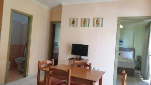 a dining room with a table with a television on it at Bayside Apartments in Vasiliki