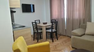 a living room with a table and chairs and a couch at Apartman river side in Soko Banja