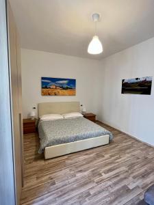 1 dormitorio con 1 cama y una pintura en la pared en Casa Cencioni en Tuscania
