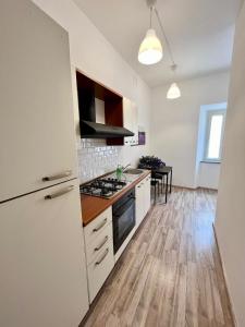 uma cozinha com armários brancos e um forno com placa de fogão em Casa Cencioni em Tuscania