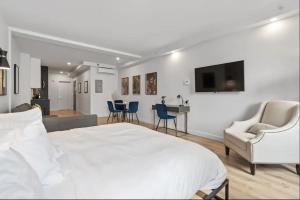 1 dormitorio con 1 cama blanca y sala de estar en INITIAL - ORIGINEL - Centre-Ville de Québec en Quebec