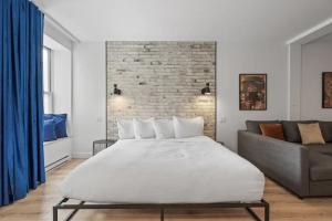 1 dormitorio con 1 cama grande y 1 sofá en INITIAL - ORIGINEL - Centre-Ville de Québec en Quebec