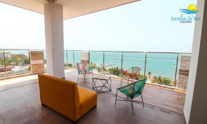 um quarto com varanda com cadeiras e vista para o mar em Arenillas del Mar em Tolú