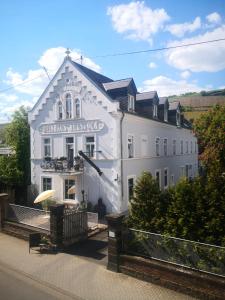 Ein weißes Gebäude mit einem Schild drauf. in der Unterkunft Altes Weingut Weinhaus Rebstock in Winningen