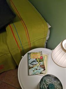 a book on a table next to a lamp at Appartamento Salvia in centro in Ascea