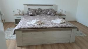 a large bed in a bedroom with two tables at Apartman river side in Soko Banja