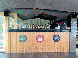 a bar with bottles of alcohol on a wooden wall at Kasauli Inn in Kasauli