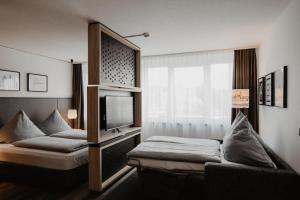 フォルヒハイムにあるArivo Forchheimのベッド2台とテレビが備わるホテルルームです。