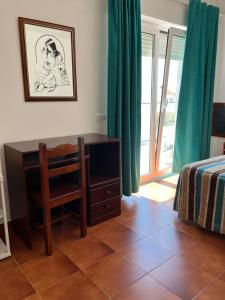 a bedroom with a desk and a chair and a bed at O Cantinho in Benavente
