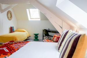 a attic bedroom with two beds and a desk at Hôtel Le Collonges TV connecté wifi Netflix in Brive-la-Gaillarde