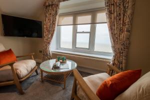 a living room with a table and a window at The Brudenell in Aldeburgh