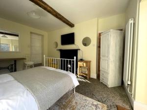 a bedroom with a white bed and a fireplace at Y Felin Bed and Breakfast and Smallholding in Caersws