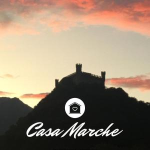 a poster of a castle with the sunset in the background at Casamarche in Montalto Dora