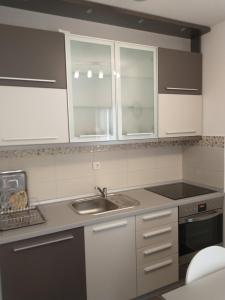 a kitchen with white cabinets and a sink at Apartment Park in Vrnjačka Banja