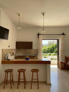 a kitchen with two bar stools and a counter top at Aeolos Apartments Kolymbari in Kolymvari