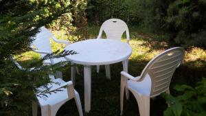 three white chairs and a white table and chairs at Apartman river side in Soko Banja
