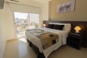 1 dormitorio con 1 cama grande y balcón en Isi Baires Alquiler Temporario en Buenos Aires