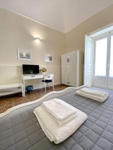 een slaapkamer met een bed en een bureau met een computer bij Duomo Rooms b&b in Lentini