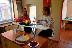 two women sitting at a table eating food at Vila Deluxe - Liptov, Bešeňová in Bešeňová