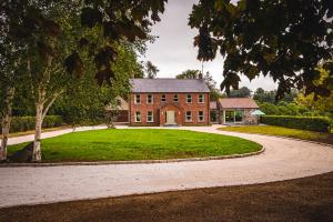 a large brick house with a circular driveway at Ballyheifer House - a beautiful 5 bedroom home. in Magherafelt