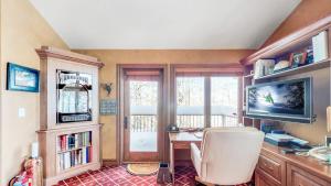 a home office with a desk and a television at Trails Edge by Snowmass Vacations in Aspen