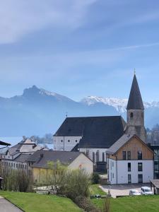 a group of buildings with a church and mountains in the background at Traum Panorama Apartment mit Berg & Seeblick in Altmünster