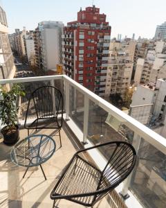 two chairs on a balcony with a view of a city at Isi Baires Alquiler Temporario in Buenos Aires