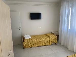 1 dormitorio con 1 cama con manta de lunares y TV en appartamento Nember, en Lido di Jesolo