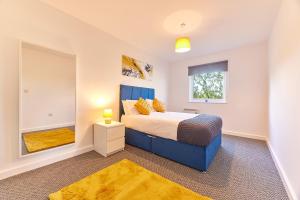 Un dormitorio con una cama azul y una ventana en The Mindrum - Properties Unique, en North Shields