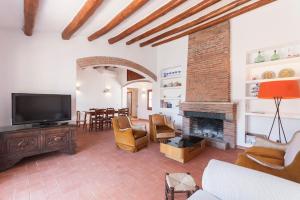 sala de estar con TV y chimenea en Let's Holidays 7 Xemeneies house en Tossa de Mar