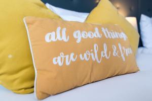 un cuscino su un letto con cuscini gialli di The Linden Leaf Rooms - Classy & Stylish a Nottingham