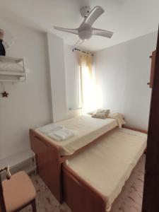 Habitación con 2 camas y ventilador de techo. en Apartamento Conil Zona tranquila con fácil aparcamiento en Conil de la Frontera