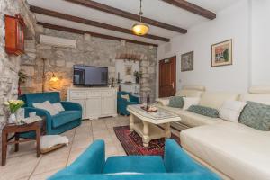 ein Wohnzimmer mit blauen Sofas und einem TV in der Unterkunft Heritage Palace LIŠTUN in Makarska
