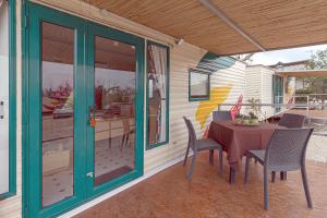 un patio con mesa y sillas en un porche en Villa Ghetta Country House en Leverano