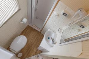 La salle de bains blanche est pourvue de toilettes et d'un lavabo. dans l'établissement Villa Ghetta Country House, à Leverano