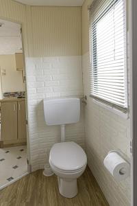 a bathroom with a white toilet and a window at Villa Ghetta Country House in Leverano