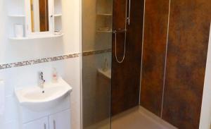 uma casa de banho com um chuveiro e um lavatório. em Ban-Car Hotel em Cairness