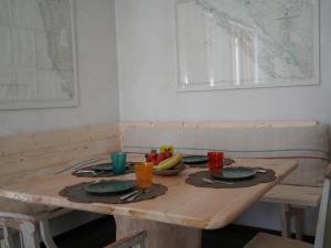 B&B Porto Del Bivio في دوينو: طاولة خشبية عليها طبقين وفواكه